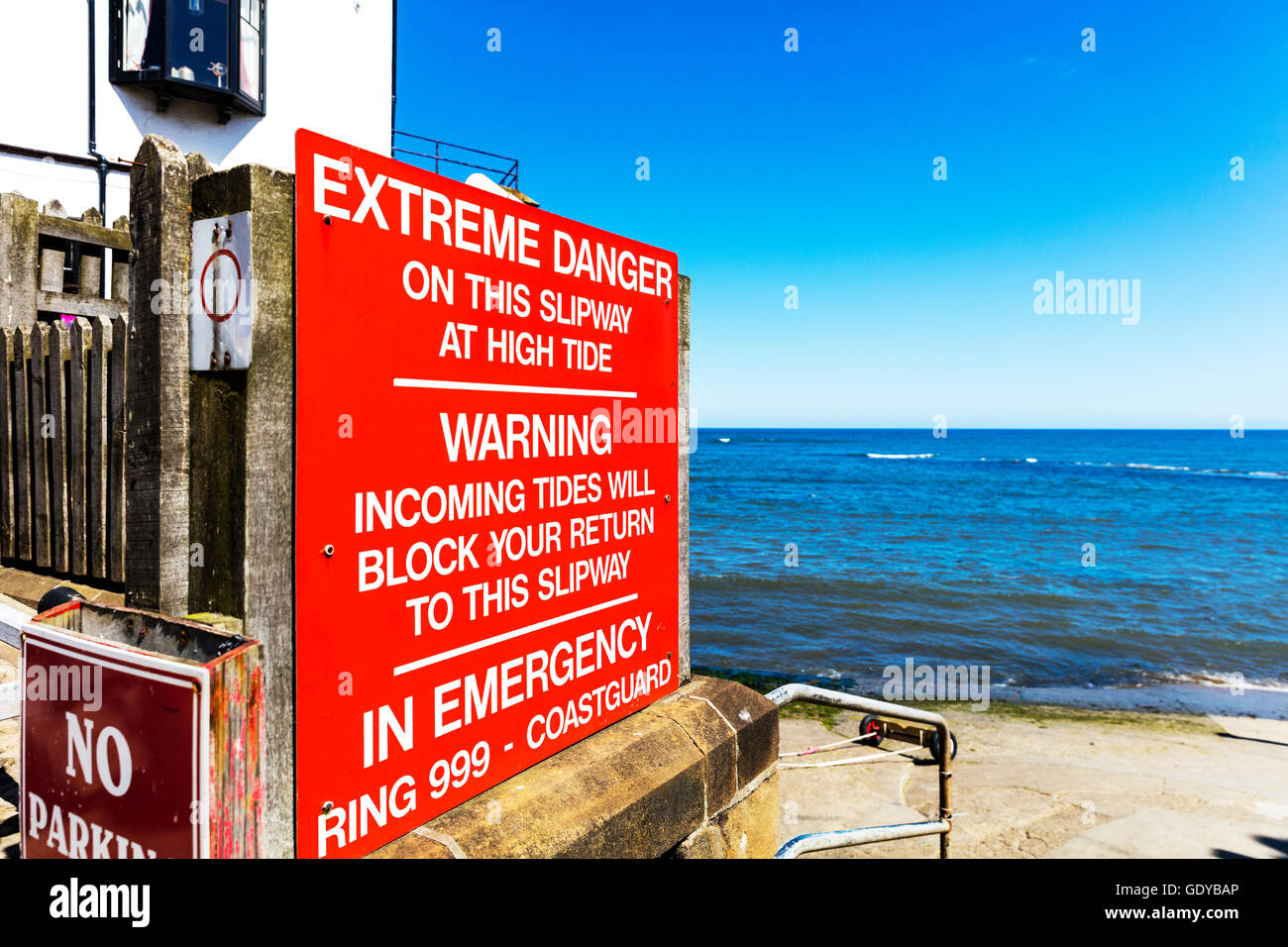 Robin cappe Bay segno di avvertimento pericolo maree in arrivo numero di emergenza Nord Yorkshire Regno Unito Inghilterra GB Foto Stock