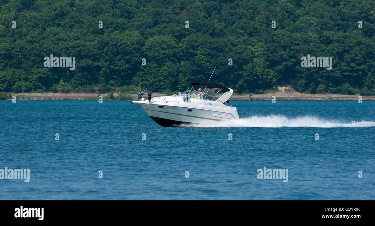 Matura in barca a motore accelerando attraverso Cayuga Lake, NY. Foto Stock