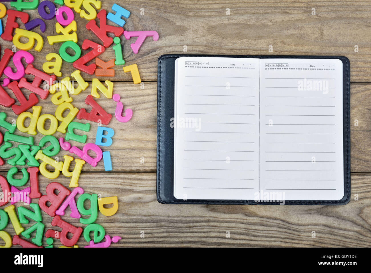 Blocco note e molte lettere sul tavolo di legno Foto Stock