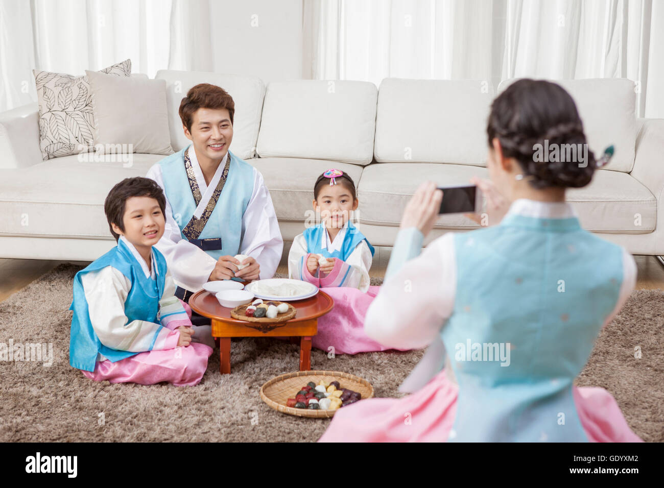 Retro della madre di scattare una foto della sua famiglia sulla Coreana tradizionale vacanza in soggiorno Foto Stock