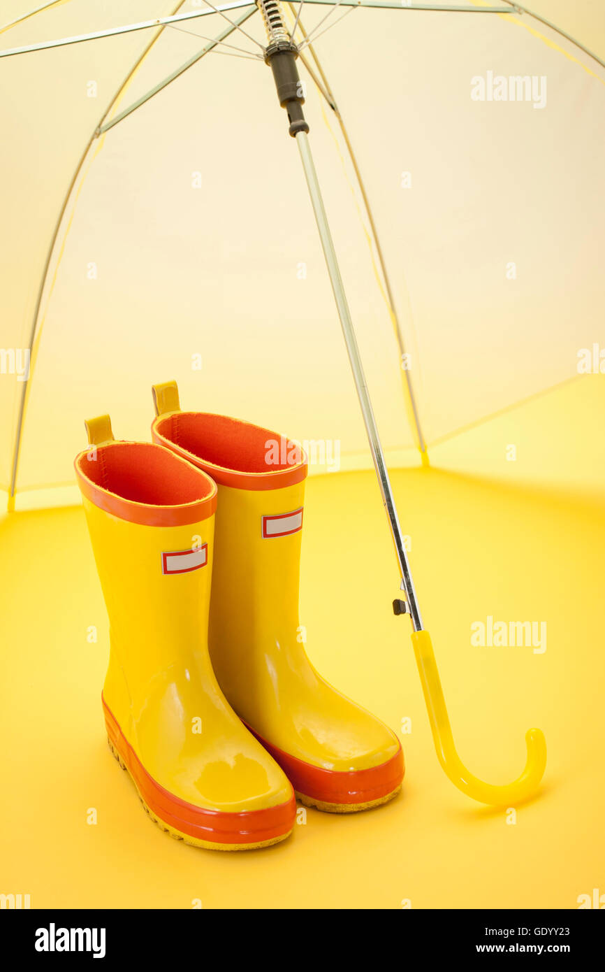 Stivali di gomma gialla e un umbrlla Foto Stock