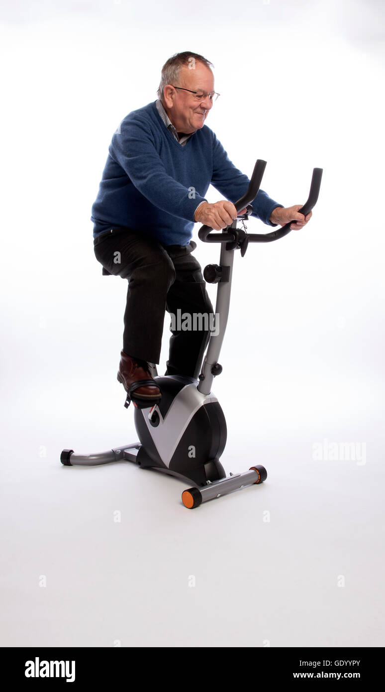 Uomo anziano sulla cyclette un uomo anziano che sta provando una cyclette Foto Stock