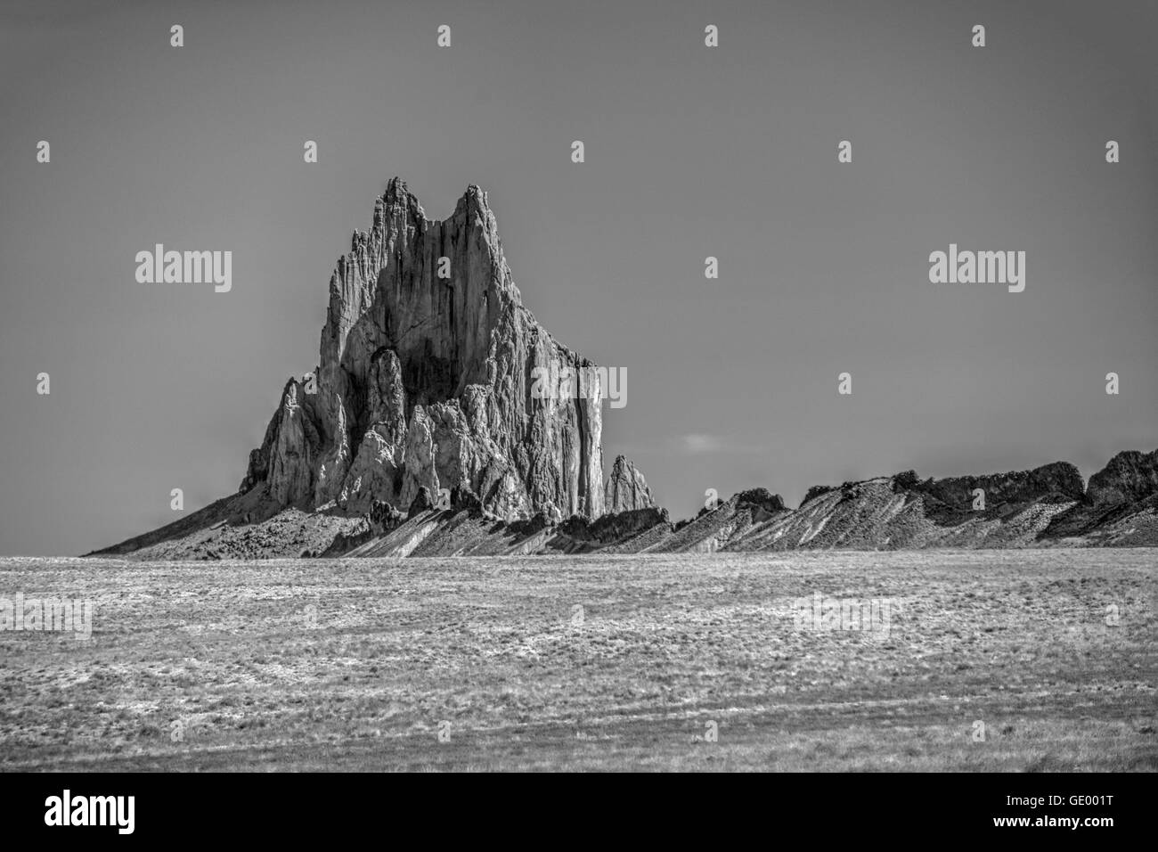 La luce del mattino su Shiprock, sacro monolito del Navajo, e uno dei suoi argini vulcaniche Foto Stock