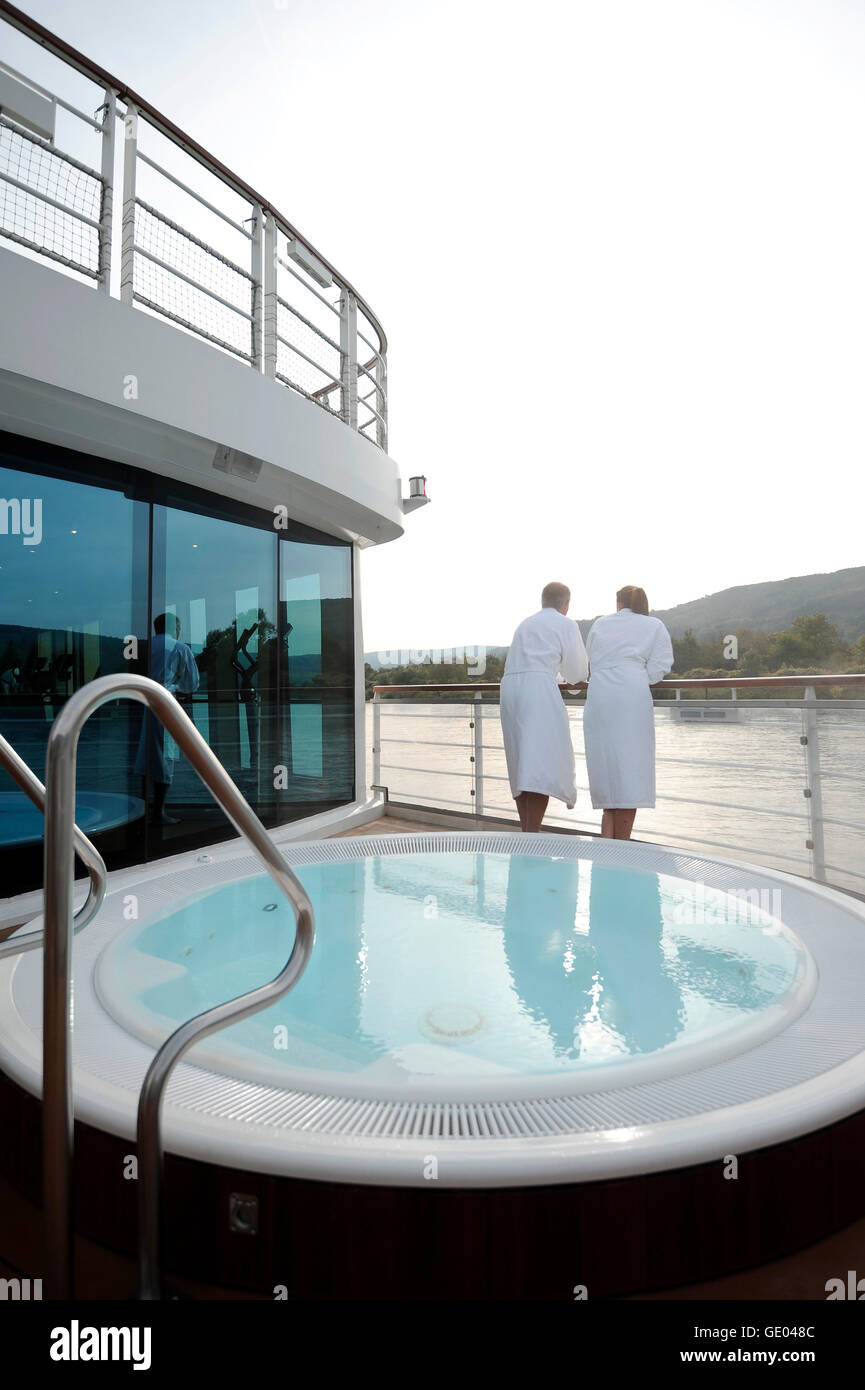 Due persone in vestaglie in prossimità di una vasca idromassaggio sulla terrazza di un fiume in barca di crociera Foto Stock