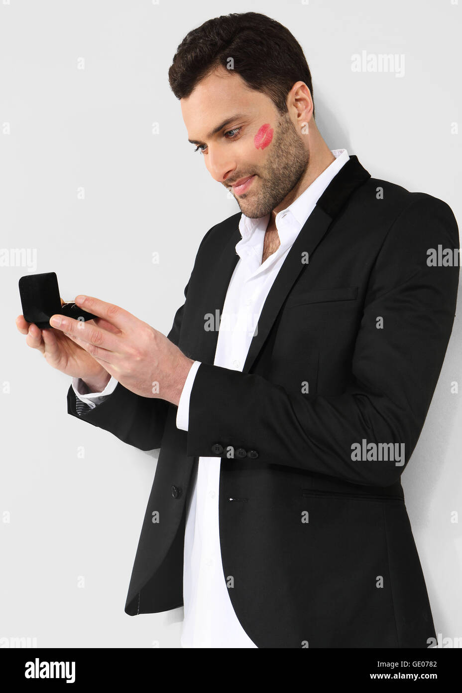 Attraente uomo guardando scatola nera con gemelli. Foto Stock