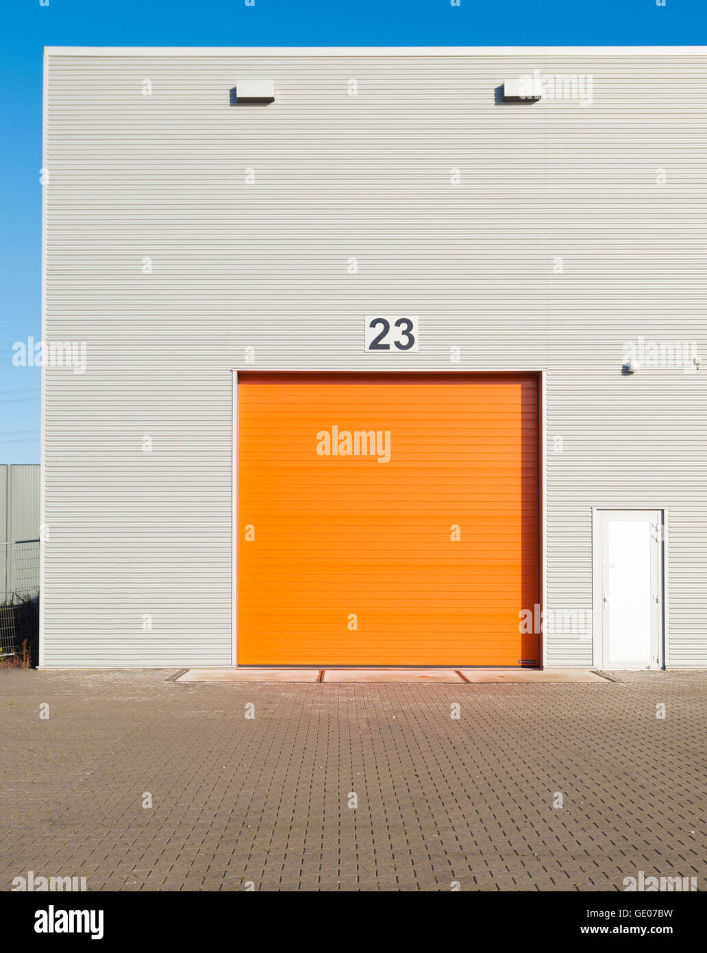 Esterno di un magazzino commerciale con un arancio porta rullo Foto Stock