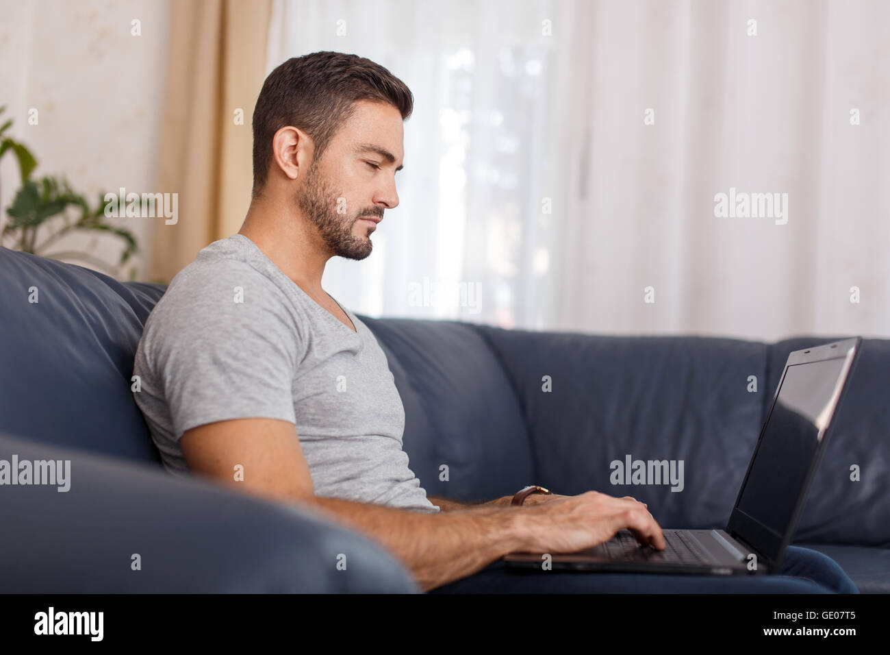 Giovani stanchi uomo informale a dormire per laptop indoor Foto Stock