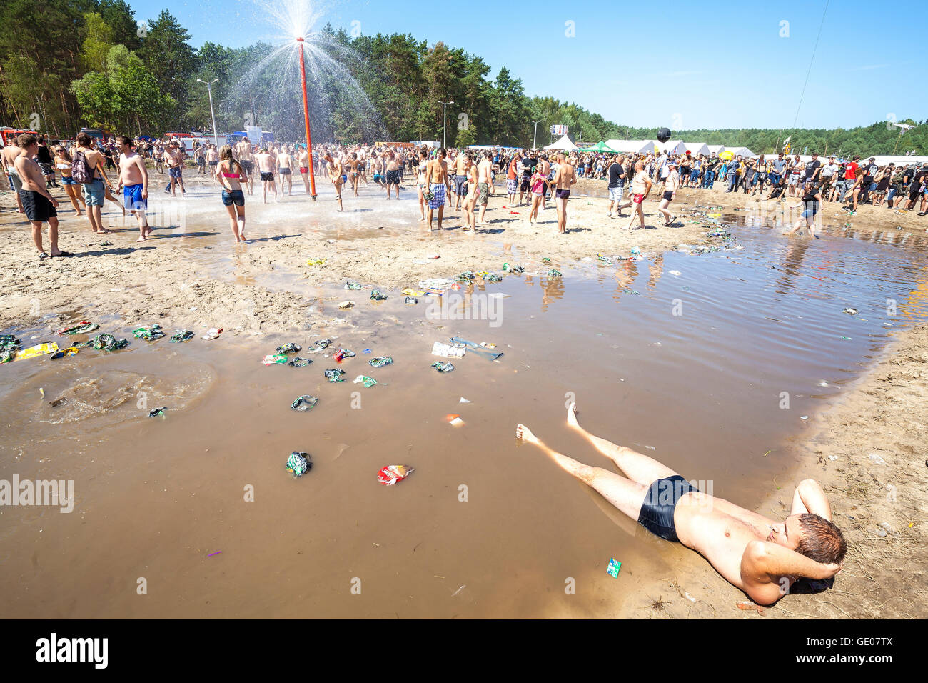 Giovane uomo in appoggio presso la piscina di fango durante il XXI festival di Woodstock in Polonia. Foto Stock
