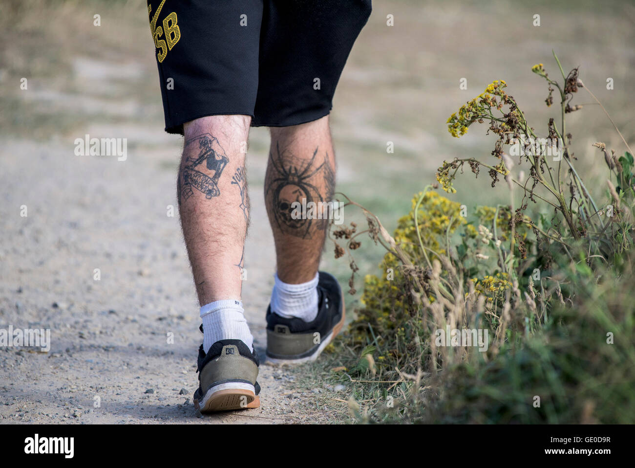 Un uomo con tatuaggi sulle sue gambe. Foto Stock