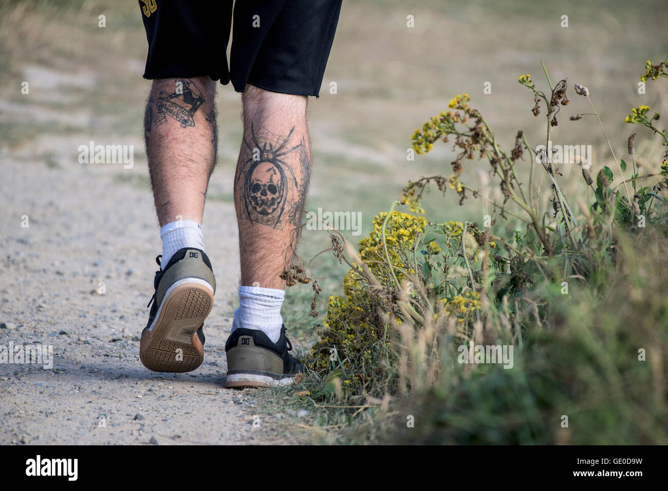 Tatuaggi sulle gambe di un uomo. Foto Stock