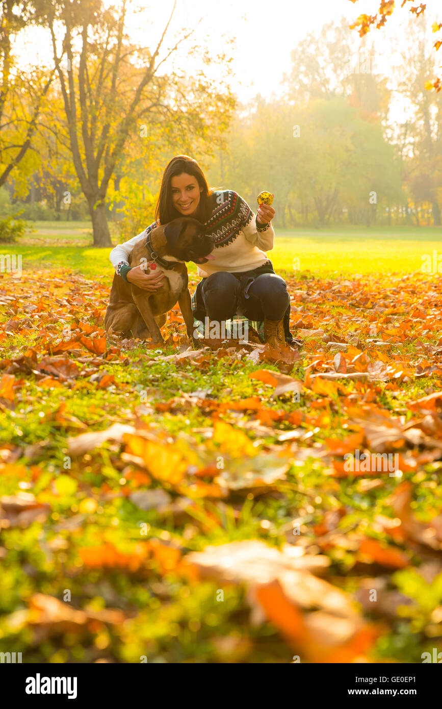 Giovane e bella donna che gioca con il suo cane nel Parco in autunno. Foto Stock