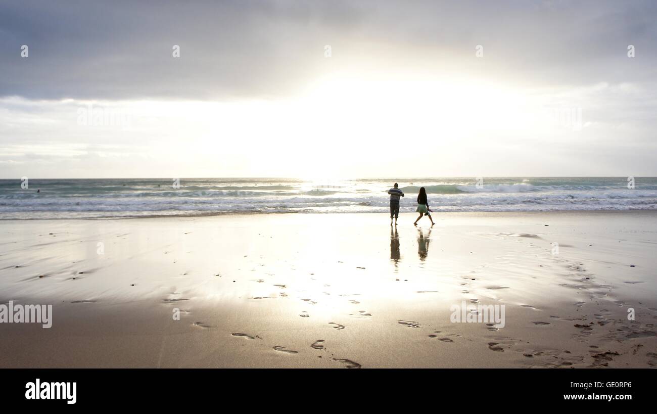 Giovane stagliano da sole luminoso sulla spiaggia con impronte nella sabbia Foto Stock