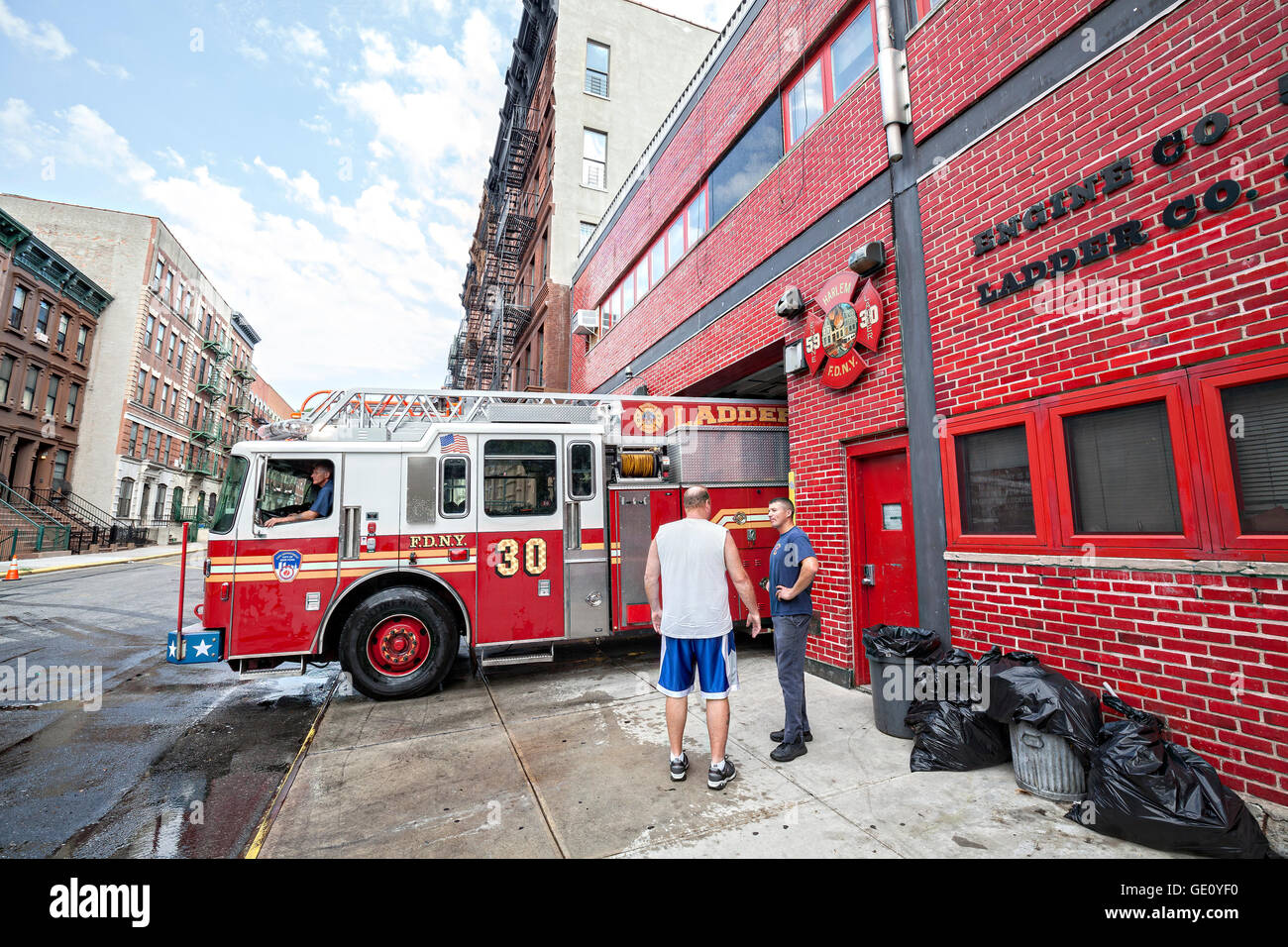 FDNY fire carro retrocede in garage in New York City quartiere di Harlem. Foto Stock