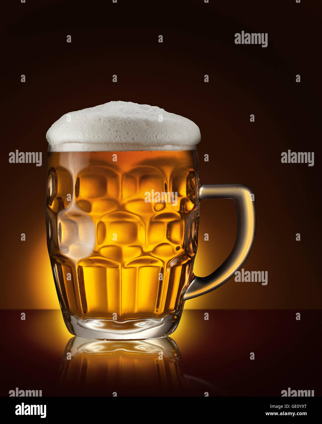 Boccale di birra sul marrone scuro dello sfondo. Foto Stock