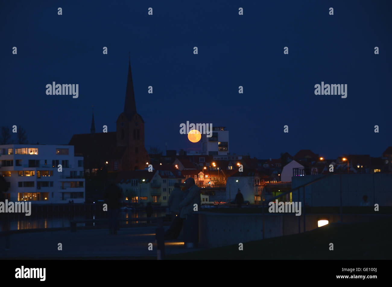 La luna piena sorge sopra lo skyline della città Sønderborg, in Danimarca. Foto Stock