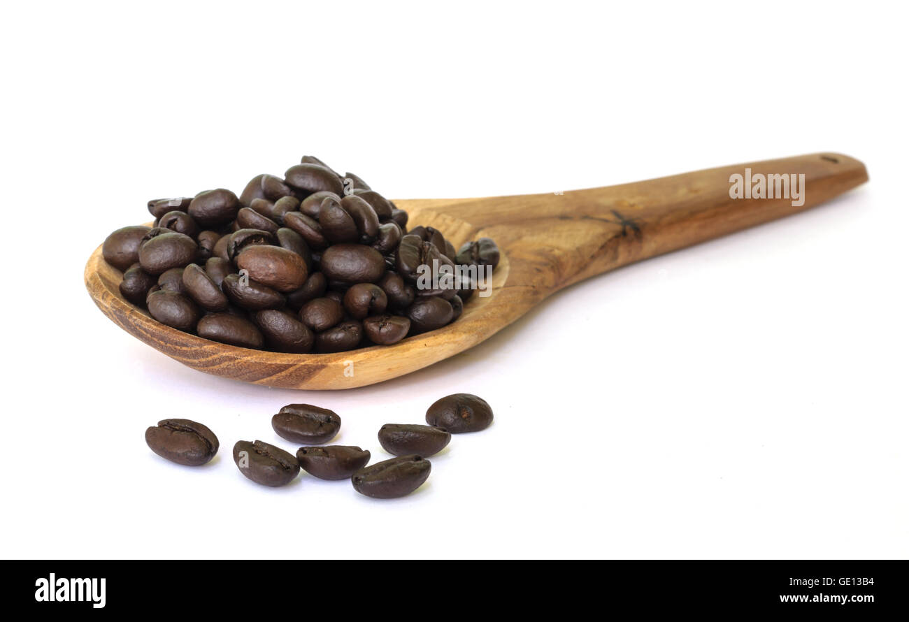 Chicco di caffè sementi sul cucchiaio di legno isolato su uno sfondo bianco. Foto Stock