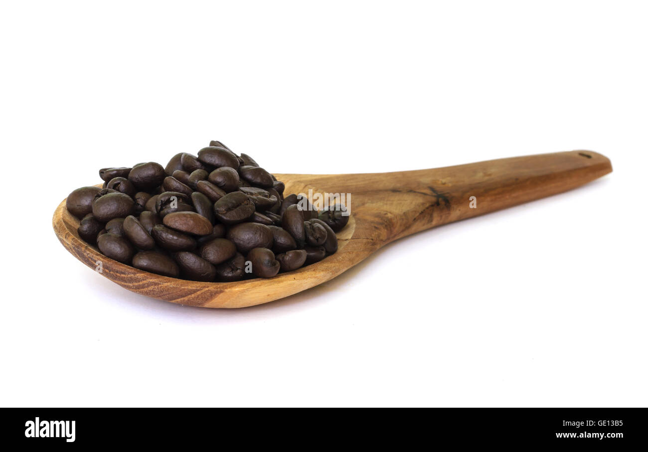 Chicco di caffè sementi sul cucchiaio di legno isolato su uno sfondo bianco. Foto Stock