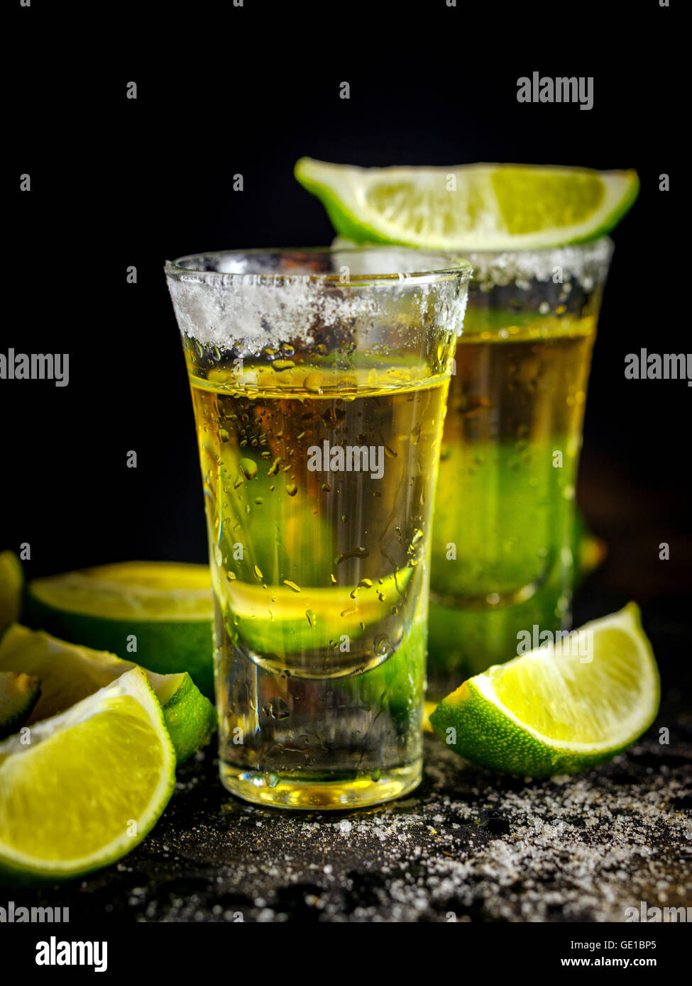 Mexican Gold Tequila con calce e sale sulla tavola nera. Due colpi di Tequila. Bere alcool. Foto Stock
