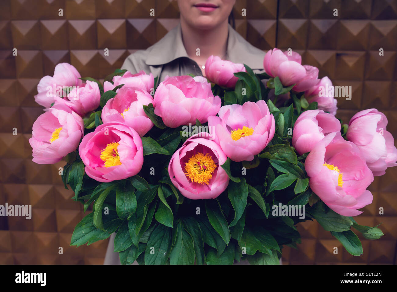 Donna che mantiene bouquet di fiori di colore rosa Foto Stock