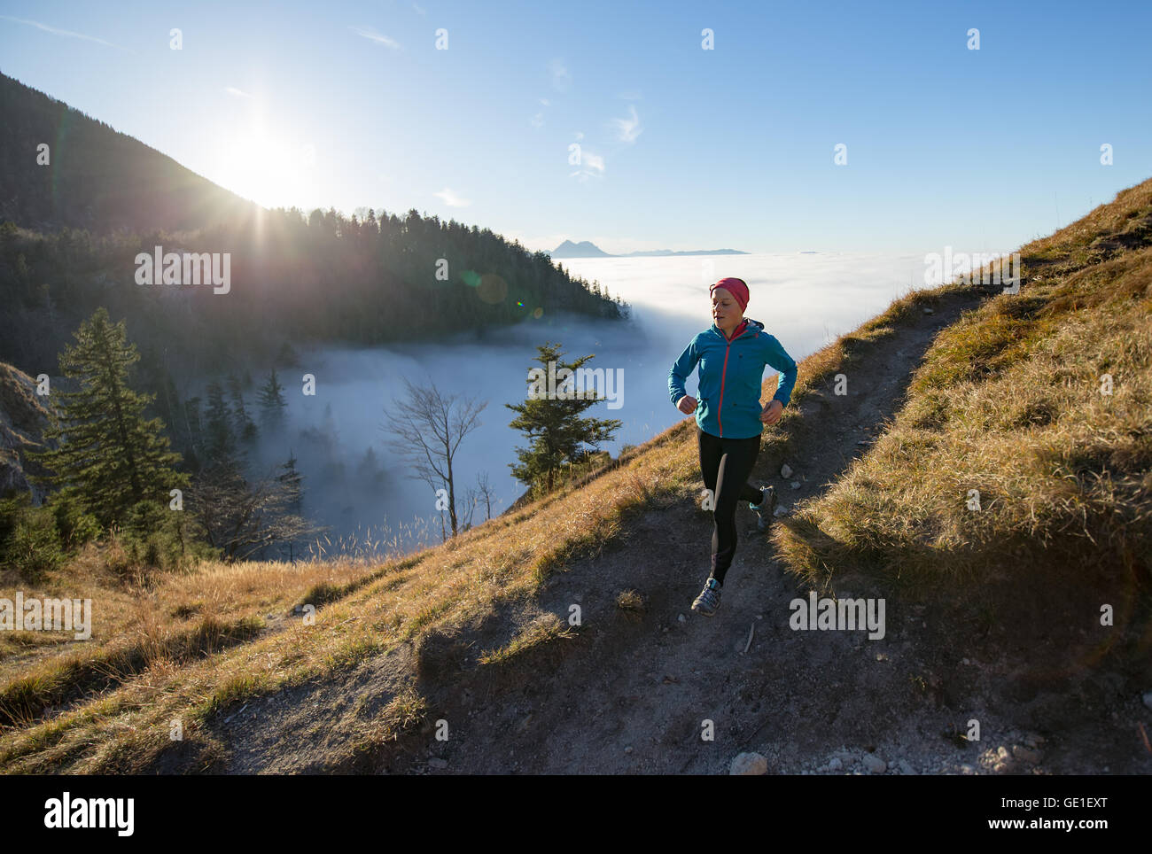 Donna Trail Running in montagna sopra le nuvole, Salisburgo, Austria Foto Stock