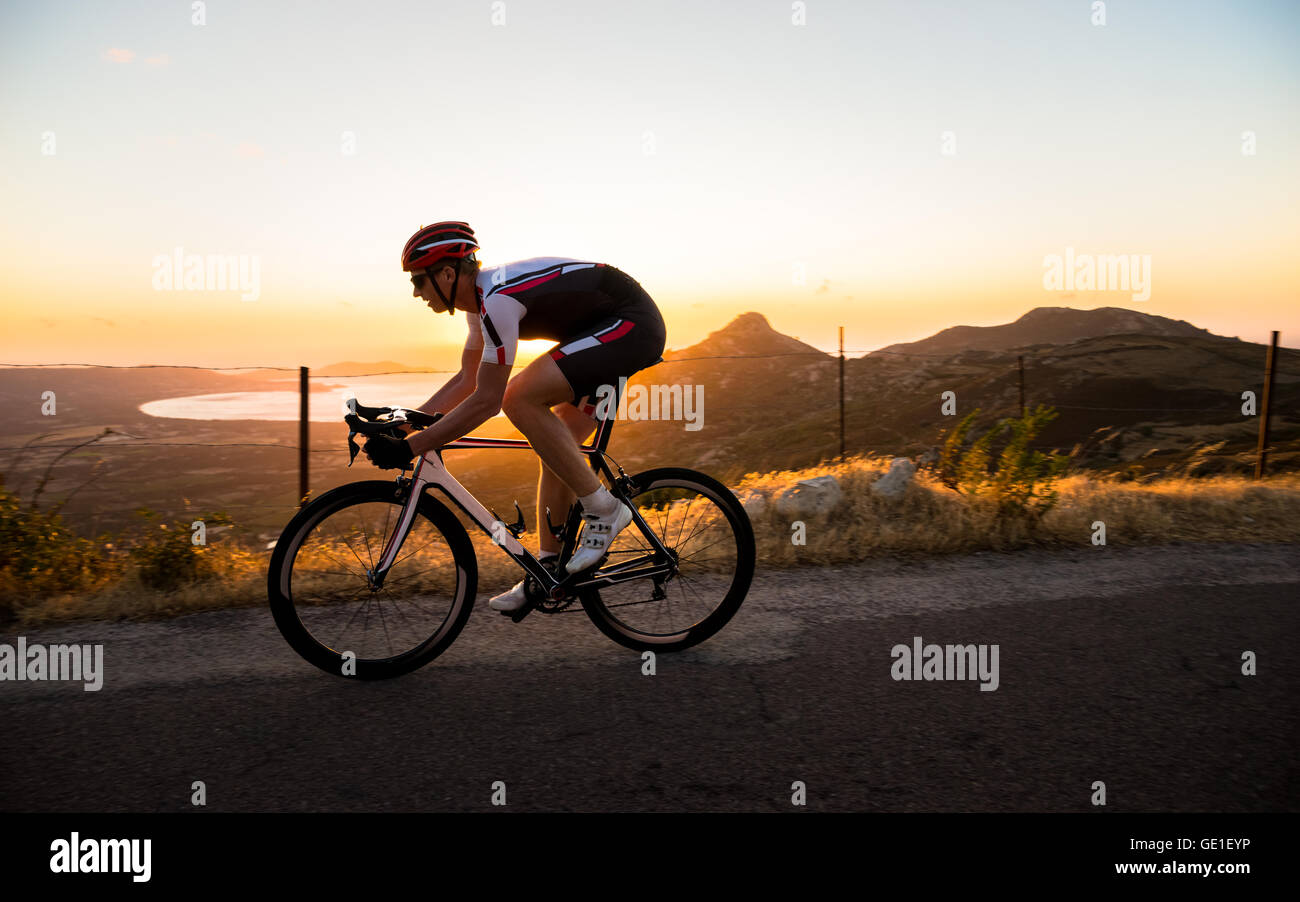 Uomo in bicicletta al tramonto, Corsica, Francia Foto Stock