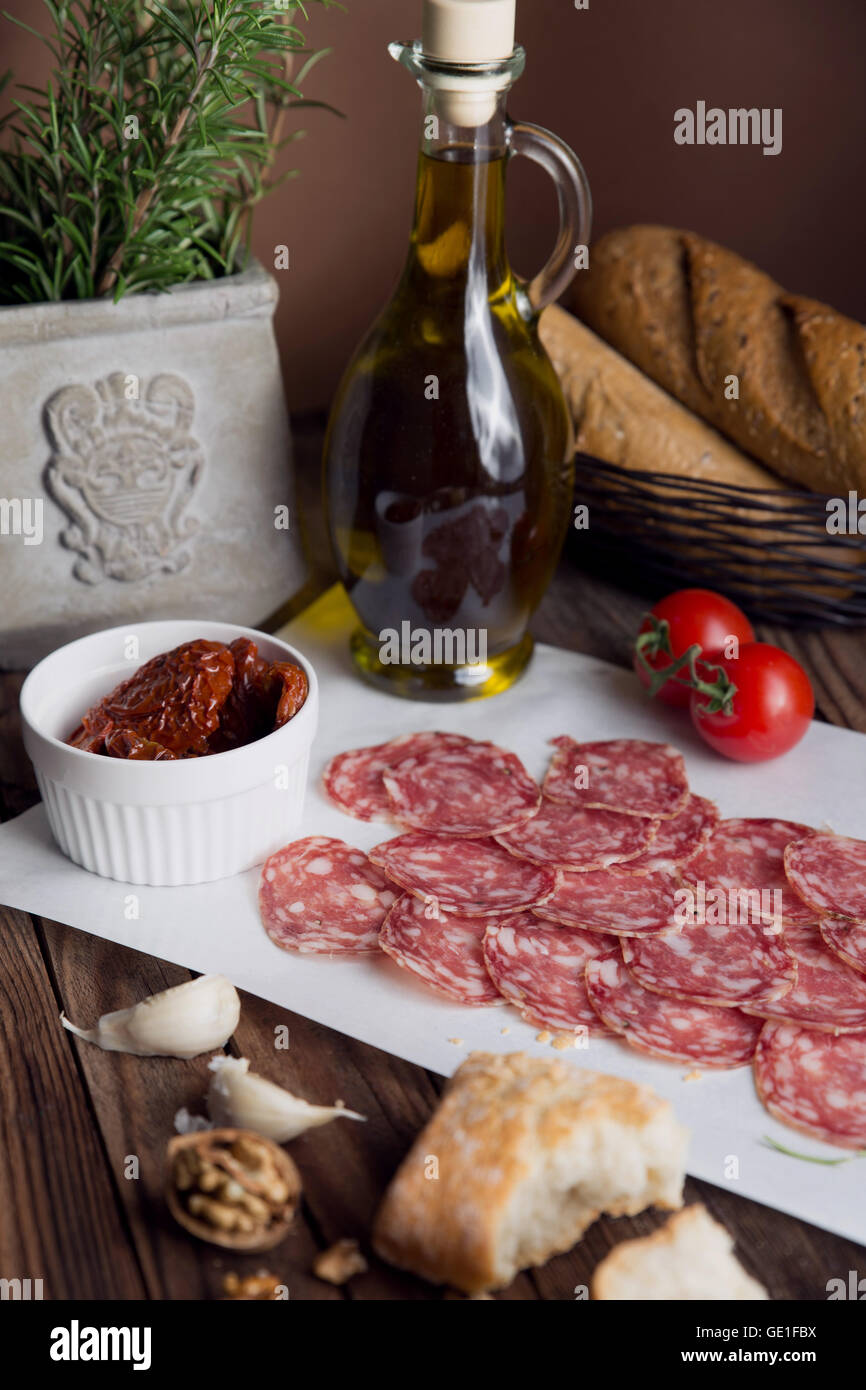 Salame, pomodori secchi, pane e olio di oliva Foto Stock