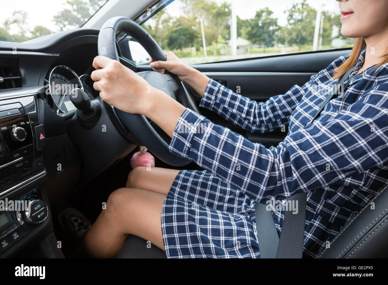 Donna alla guida di una vettura con un sorriso Foto Stock