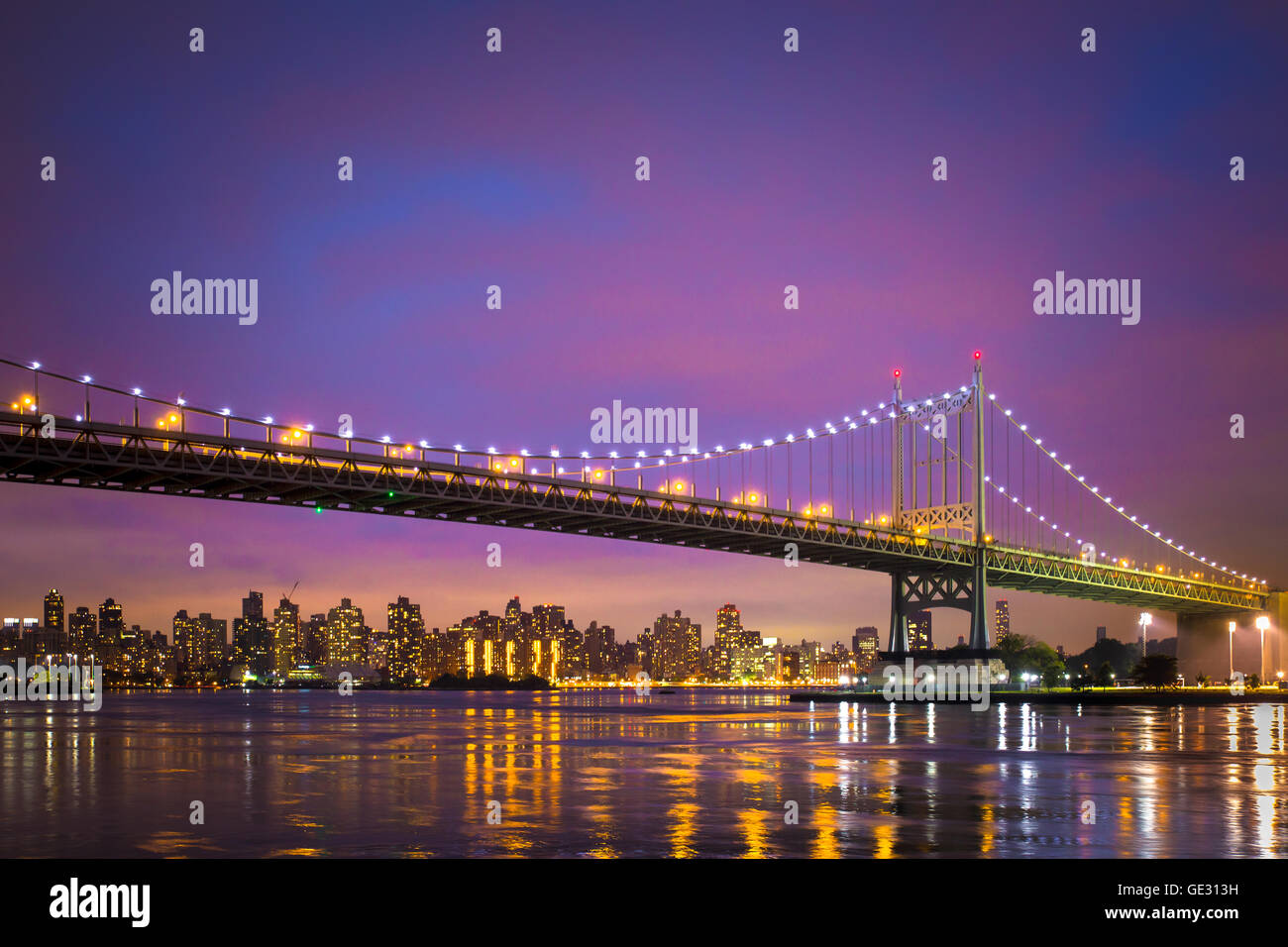 Vista del Robert J. Kennedy RFK bridge in New York City da Astoria Queens a Manhattan visibile appena dopo il tramonto con luci Foto Stock