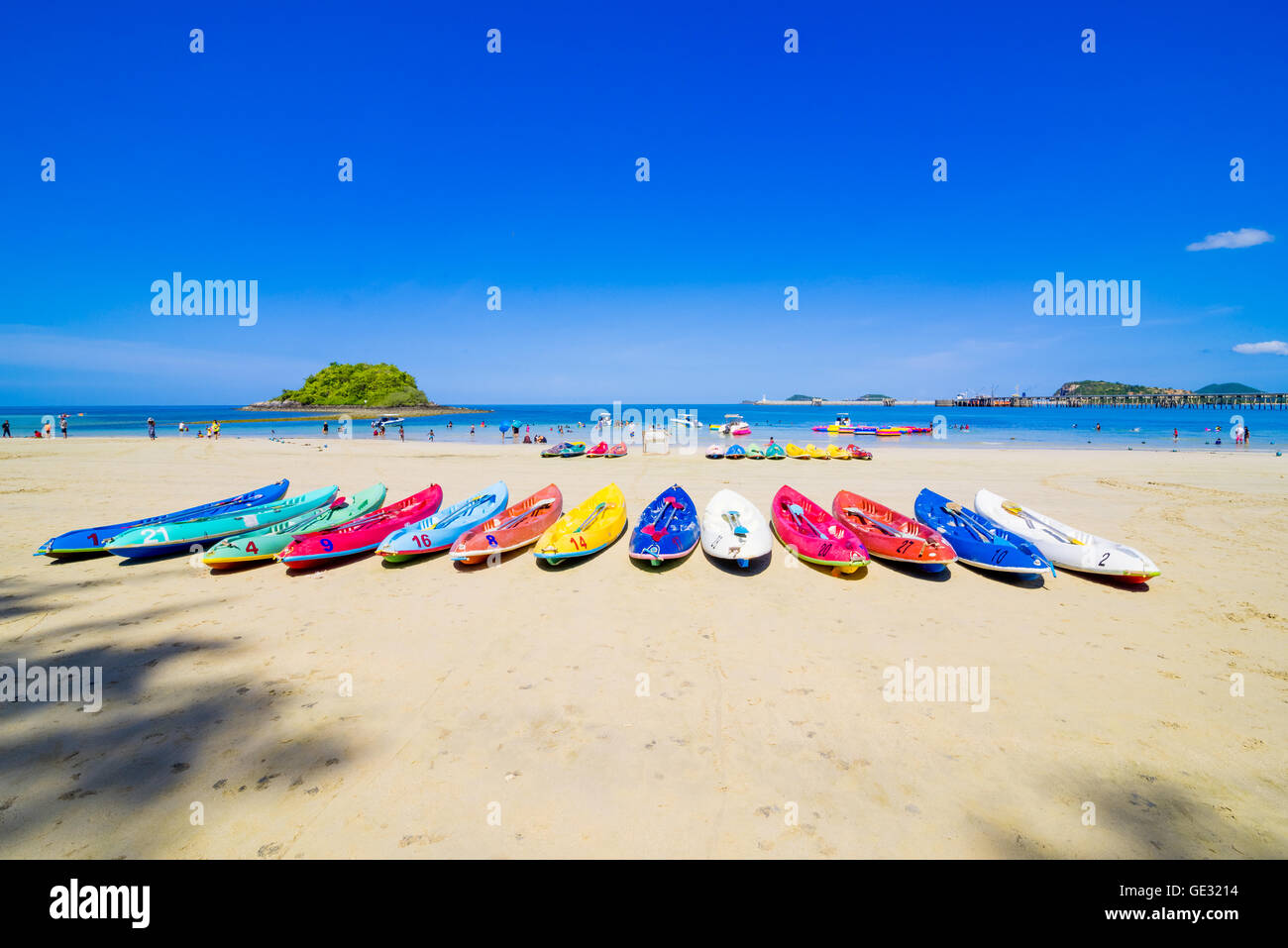 Surfer sulla bella spiaggia e mare con barca a vela e le nuvole in distanza Foto Stock