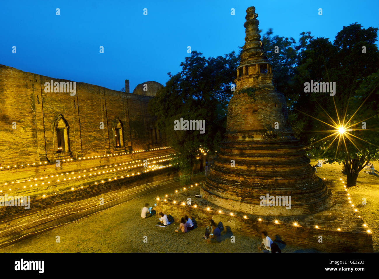 La luce di una candela triple circumambulation attività intorno alla pagoda di Buddha nel tempio di Wat Maheyong Ayutthaya Thailandia Foto Stock