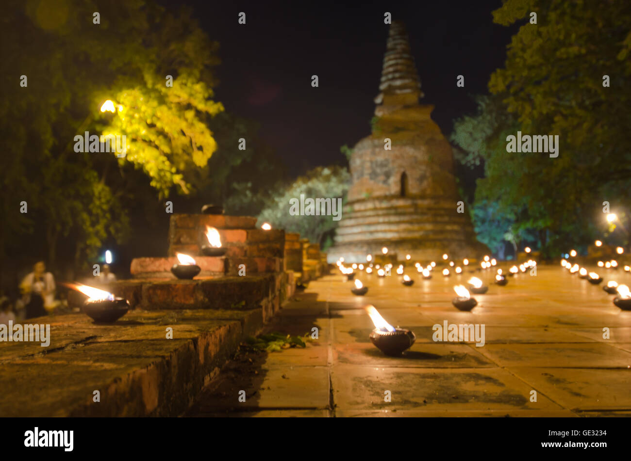 Serie di luce di candela intorno alla pagoda di Buddha nel tempio di Wat Maheyong Ayutthaya Thailandia Foto Stock