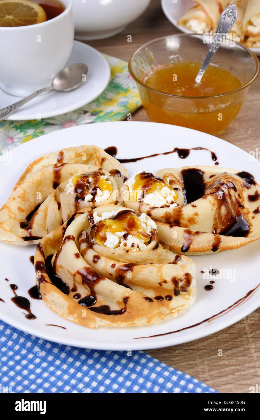 Pancake piegato nella forma di una lumaca per la ricotta con il cioccolato Foto Stock