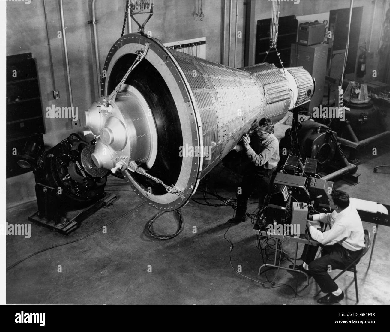 (1960) Guardando come una scena di un H.G. Pozzetti nuovi ingegneri, ispezionare e testare un mercurio boilerplate navicella spaziale. Nota la matrice di ingombranti apparecchiature di prova sul tavolo e la meno di clean room condizioni. Oggi tale prova è condotta praticamente in condizioni di steril completamente in ambiente controllato. Immagine # : MERCAP Foto Stock