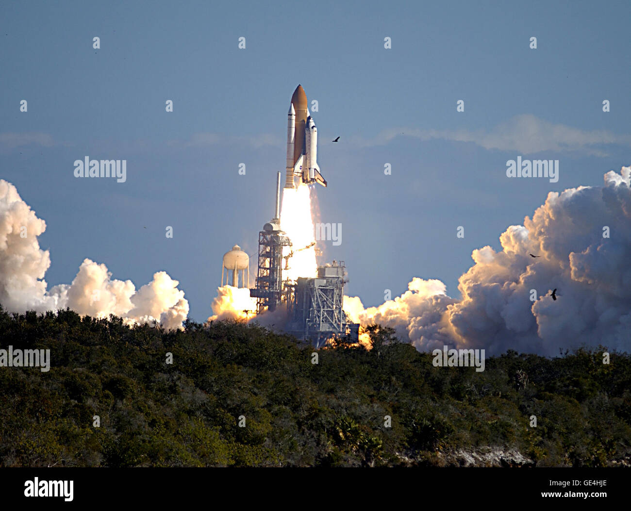 Attraverso un cloud-lavato il cielo blu sopra Launch Pad 39A, lo Space Shuttle Columbia hurtles verso lo spazio sulla missione STS-107. In seguito il conto alla rovescia, si è verificato un sollevamento verticale del tempo di inserimento a 10:39 EST. Esperimenti nel modulo SPACEHAB variava tra scienze dei materiali per le scienze della vita. Immagine #: KSC-03PD-0113 Data: 16 gennaio 2003 Foto Stock