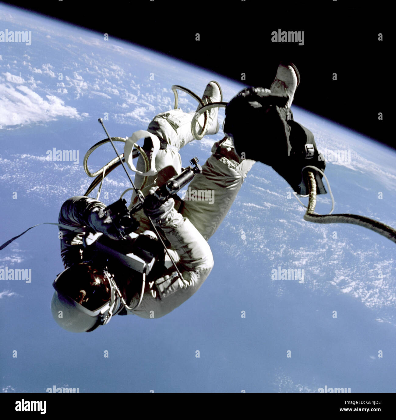 Edward H. White II, pilota della Gemini 4 veicoli spaziali, galleggianti in gravità zero dello spazio con un lembo di terra sullo sfondo. Il extravehicular attività è stata eseguita nel corso del terzo giro della Gemini 4 veicoli spaziali e rappresenta la prima volta che un americano ha intensificato al di fuori dei confini della sua navicella spaziale. Il bianco è fissato al veicolo spaziale da un 25-ft. linea ombelicale e un 23-ft. tether linea, entrambi avvolti in oro nastro per formare un cordone. Nella sua mano destra bianco porta un cronometro Self-Maneuvering unità (HHSMU). La visiera del suo casco è placcato in oro per proteggerlo dai raggi non filtrata di Foto Stock