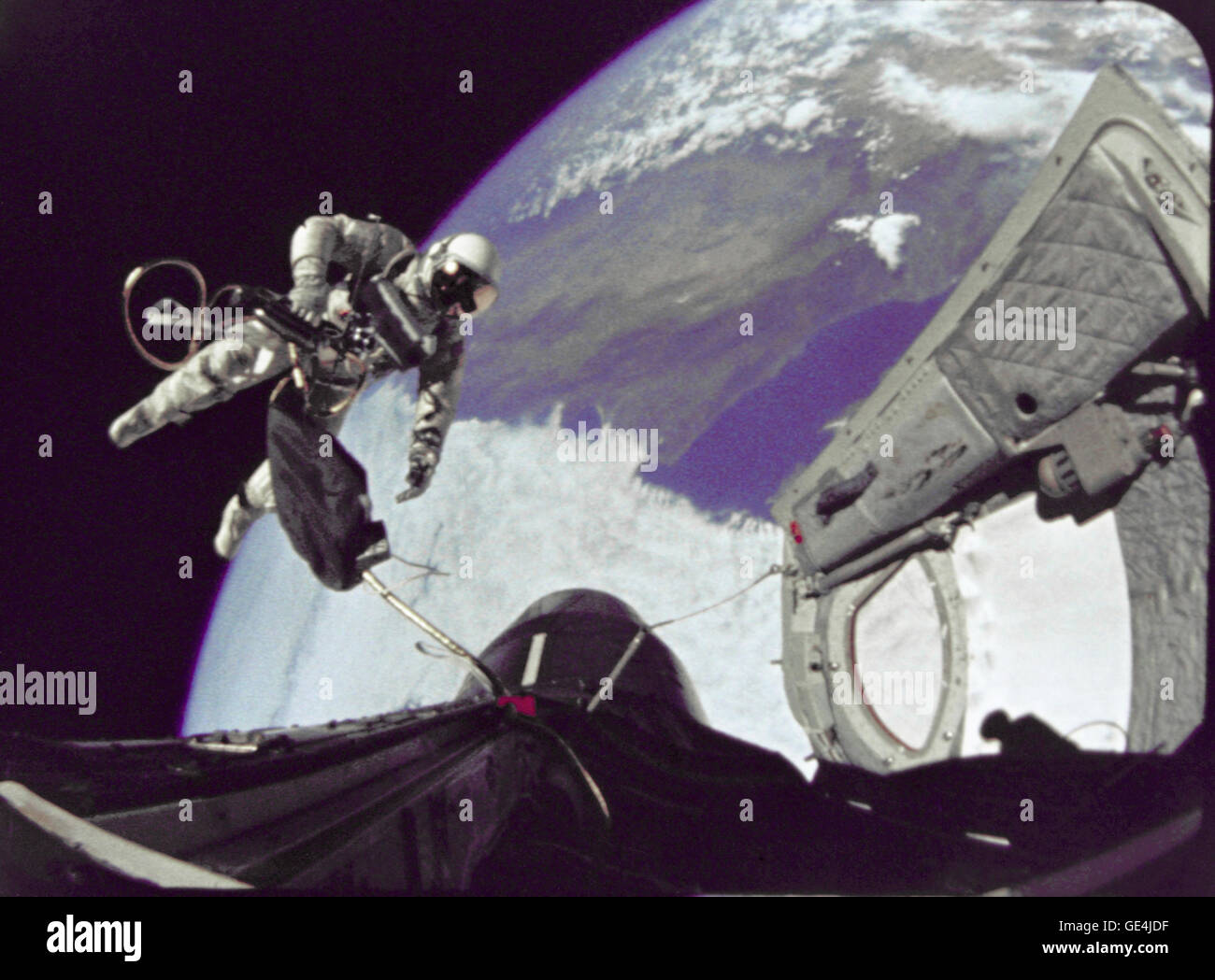 Astronauta Edward H. White II, pilota per la Gemini-Titan 4 volo spaziale, galleggia in gravità zero dello spazio. Il extravehicular attività è stata eseguita nel corso del terzo giro della Gemini 4 veicolo spaziale. Il bianco è fissato al veicolo spaziale da un 25-ft. linea ombelicale e un 23-ft. tether linea, entrambi avvolti in oro nastro per formare un cordone. Nella sua mano destra bianco porta un cronometro Self-Maneuvering unità (HHSMU). La visiera del suo casco è placcato in oro per proteggerlo dai raggi non filtrata del sole. Immagine # : S65-29730 Foto Stock