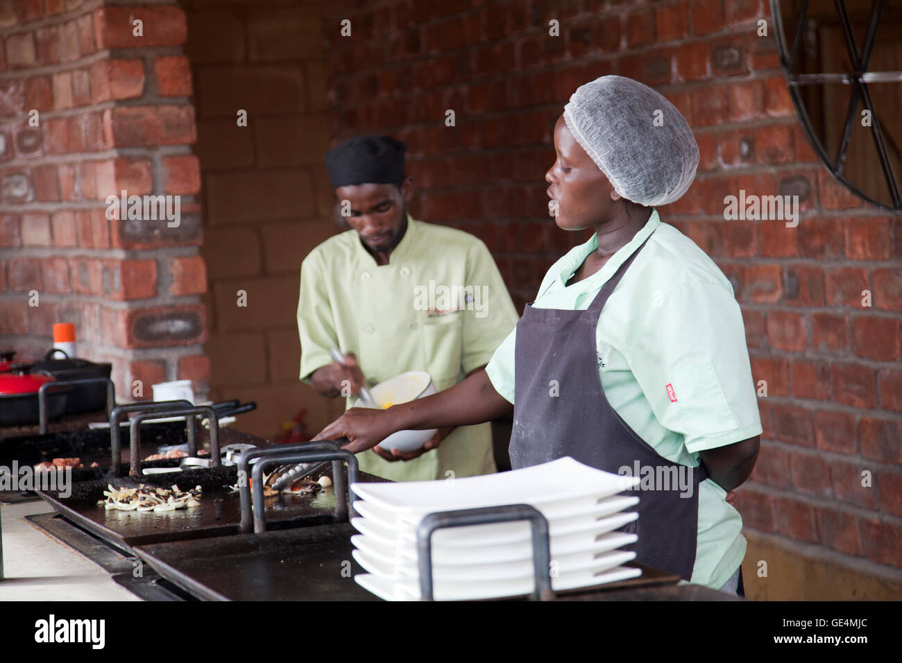 Il personale la cottura alla griglia di cibi per la prima colazione a pianure Camp in l'Okonjima - Namibia Foto Stock