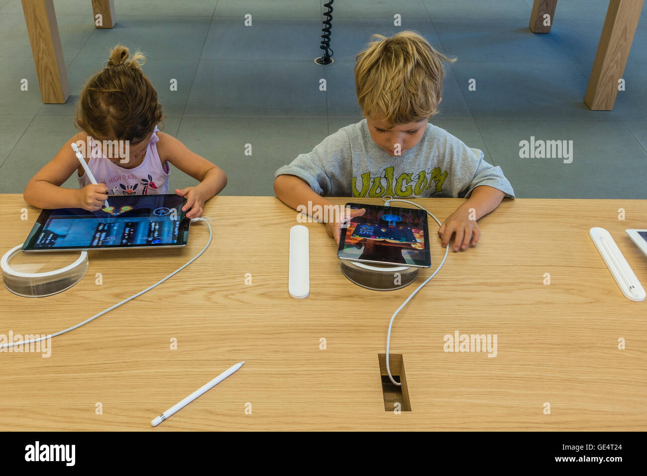 Due bambini 6-8 anni provare ipad presso un Apple Store su State Street a Santa Barbara, California. Foto Stock
