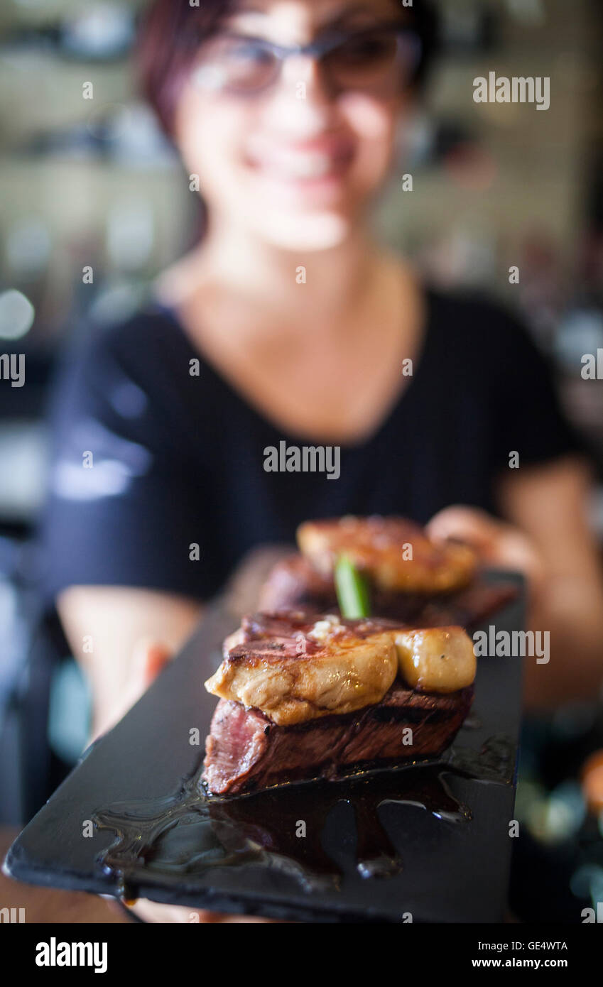 Cameriera mostra una Tapa, il filetto di manzo con foie, Bar Mut, Pau Claris 192, Barcellona, Spagna Foto Stock