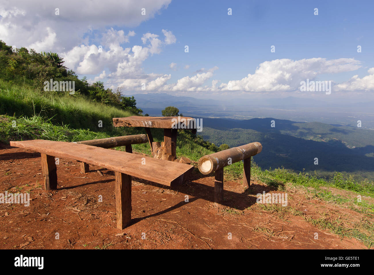 Vista del tavolo e sedie; erba; montagna; e nuvoloso cielo blu nella città di Chiangmai Thailandia Foto Stock