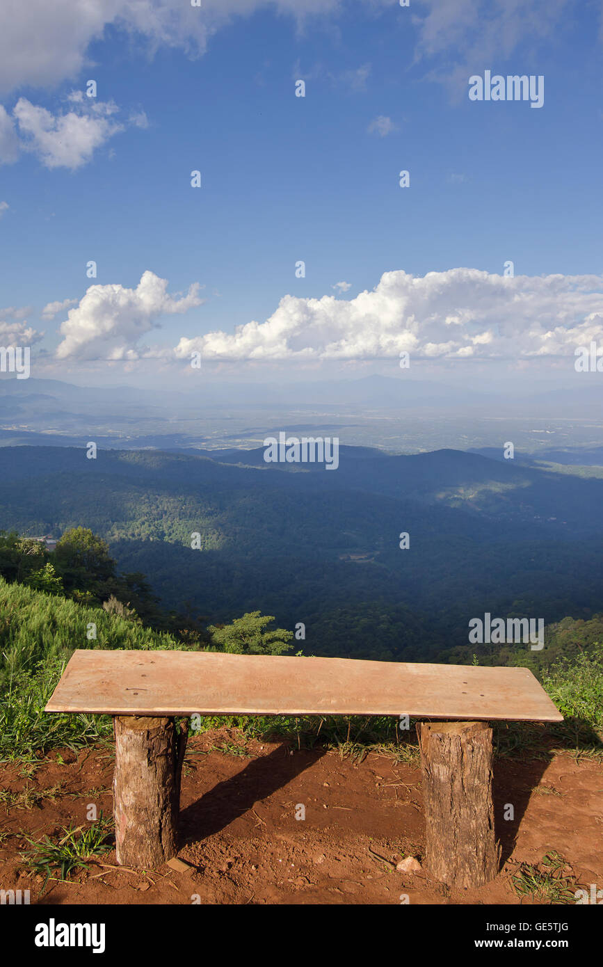 Vista di una sedia solitaria, erba, mountain e nuvoloso cielo blu nella città di Chiangmai Thailandia Foto Stock