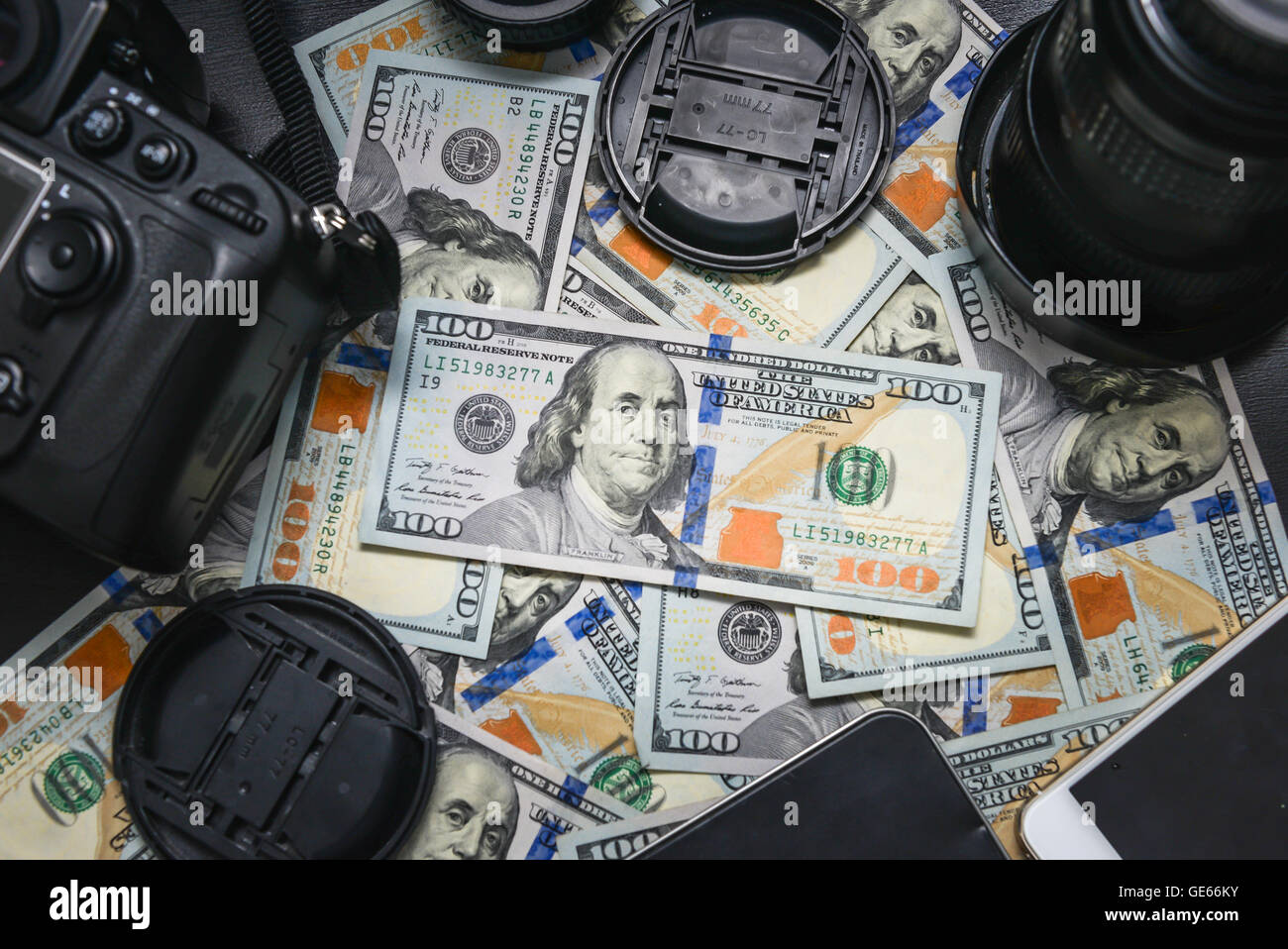 Sfondo American banconote da cento dollari e fotocamera DSLR dispositivi. Fare un sacco di soldi da fotocamera reflex digitale, successo business con Foto Stock