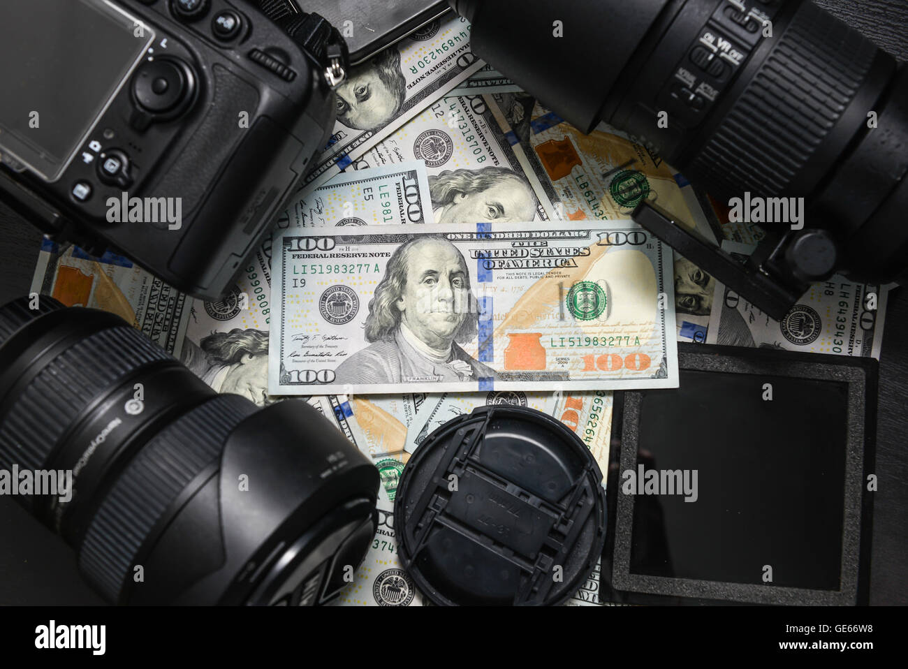 Sfondo American banconote da cento dollari e fotocamera DSLR dispositivi. Fare un sacco di soldi da fotocamera reflex digitale, successo business con Foto Stock
