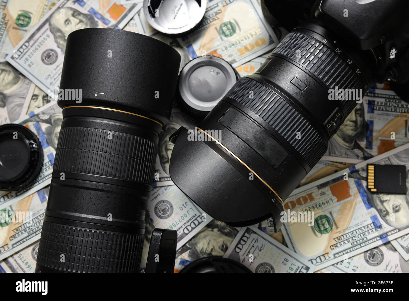 Sfondo American banconote da cento dollari e fotocamera DSLR dispositivi. Fare un sacco di soldi da fotocamera reflex digitale, business di successo Foto Stock