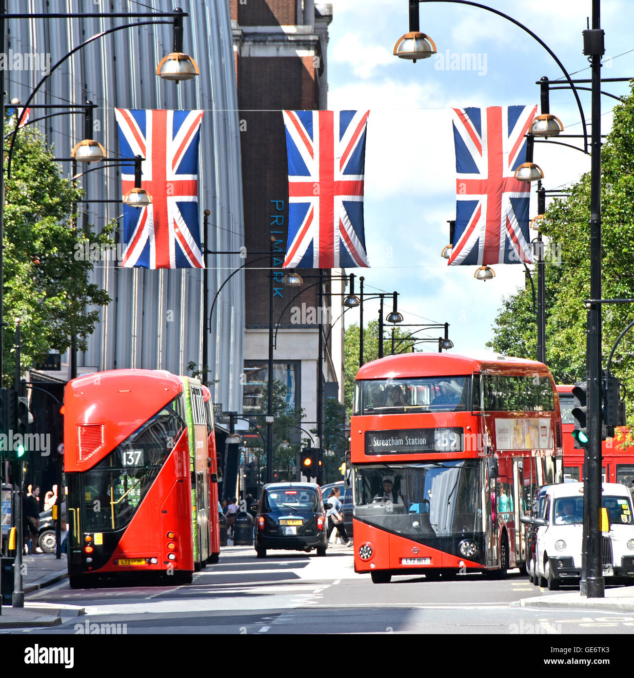 Oxford Street West End di Londra Inghilterra REGNO UNITO nuova red double decker bus Routemaster sotto Union Jack Flag in questo frenetico shopping al dettaglio street Foto Stock