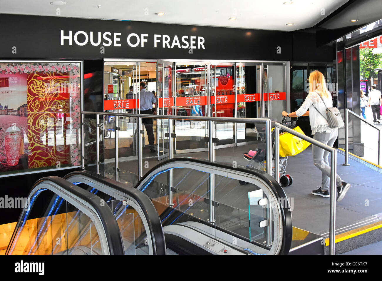 Porta al piano terra con ingresso di Oxford Street il ramo di House of Fraser department store con scale mobili al piano seminterrato cliente con passeggino Foto Stock