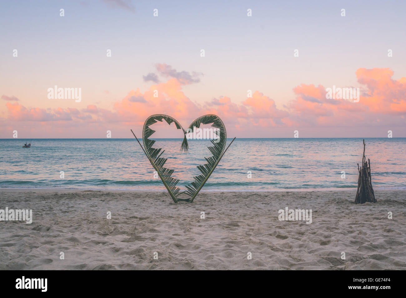 Palm tree rami sono legati a forma di cuore, su una tranquilla spiaggia dell'isola di Koh Pha Ngan, della Thailandia . Foto Stock