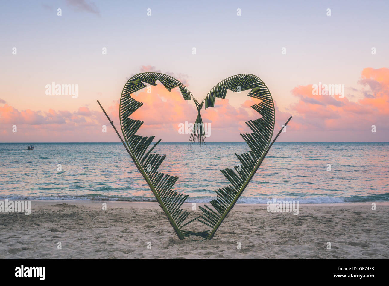 Palm tree rami sono legati a forma di cuore, su una tranquilla spiaggia dell'isola di Koh Pha Ngan, della Thailandia . Foto Stock
