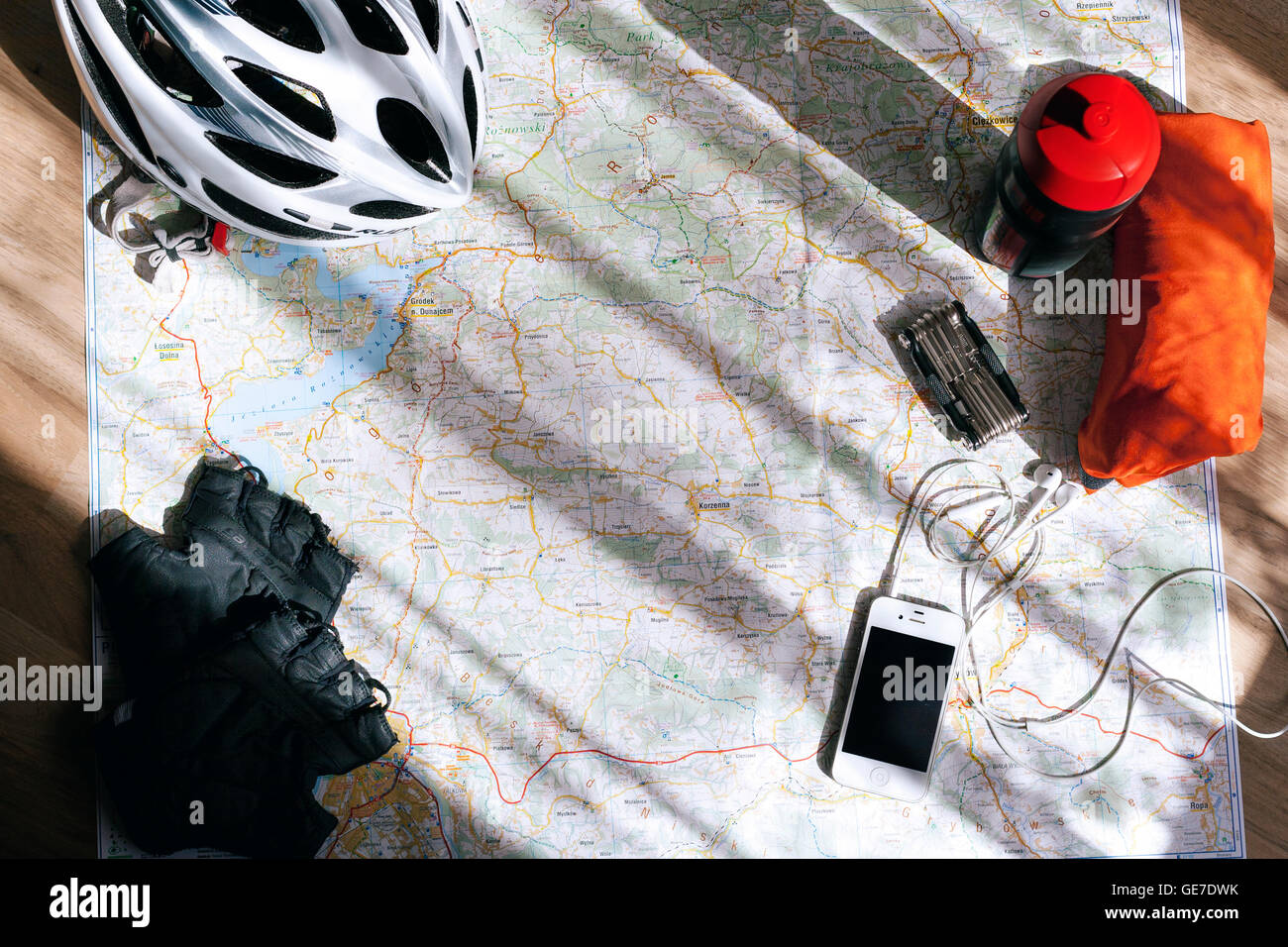 Accessori per biciclette sparsi sulla mappa durante la pianificazione di un viaggio in bicicletta nelle montagne polacche. Foto Stock