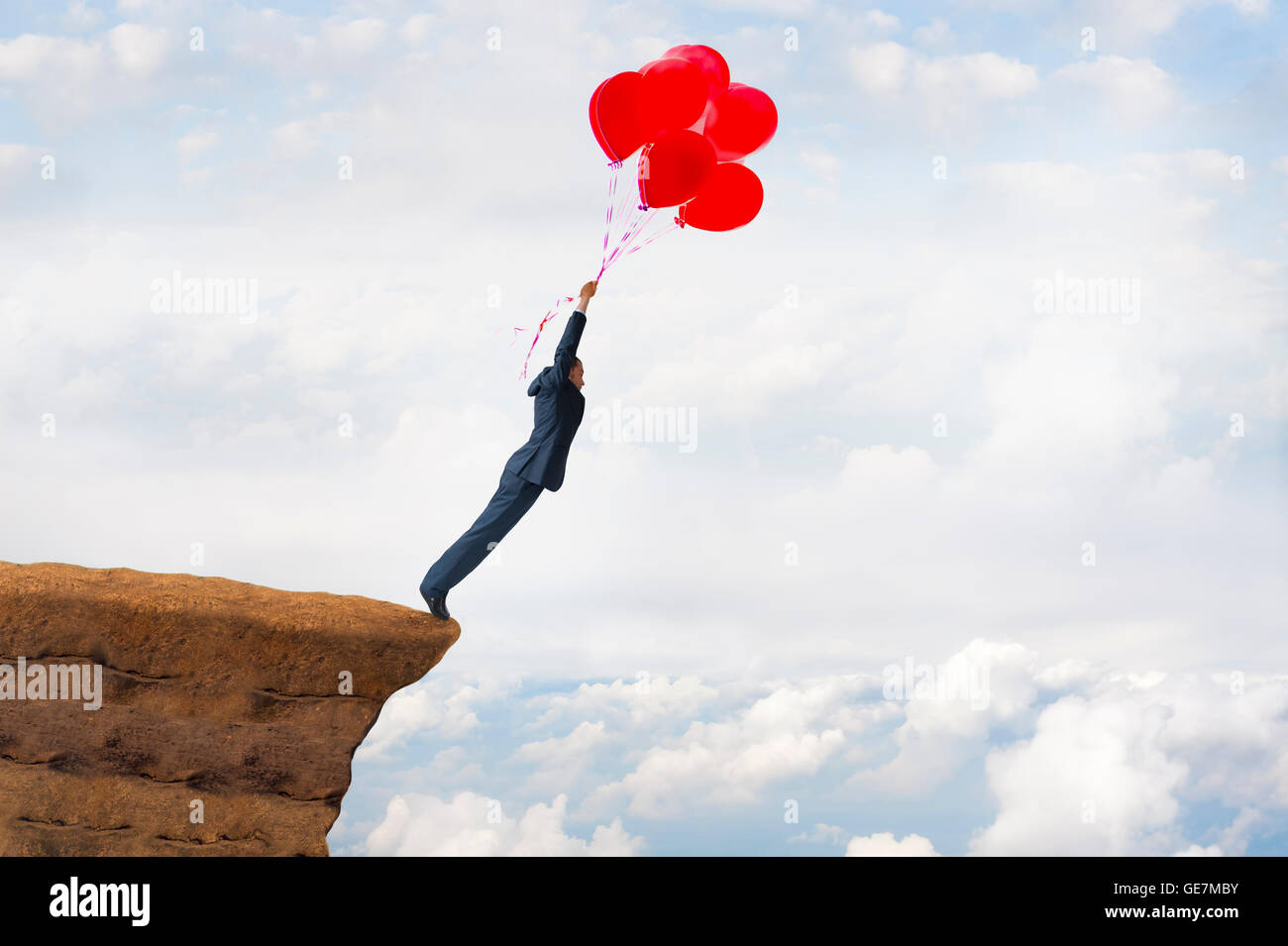 Business Libera concetto coraggioso imprenditore audace battenti fuori da una scogliera tenendo fede in palloncini Foto Stock